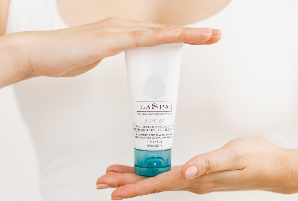 hands holding LASPA Tinted SPF 20 Mineral Sunscreen